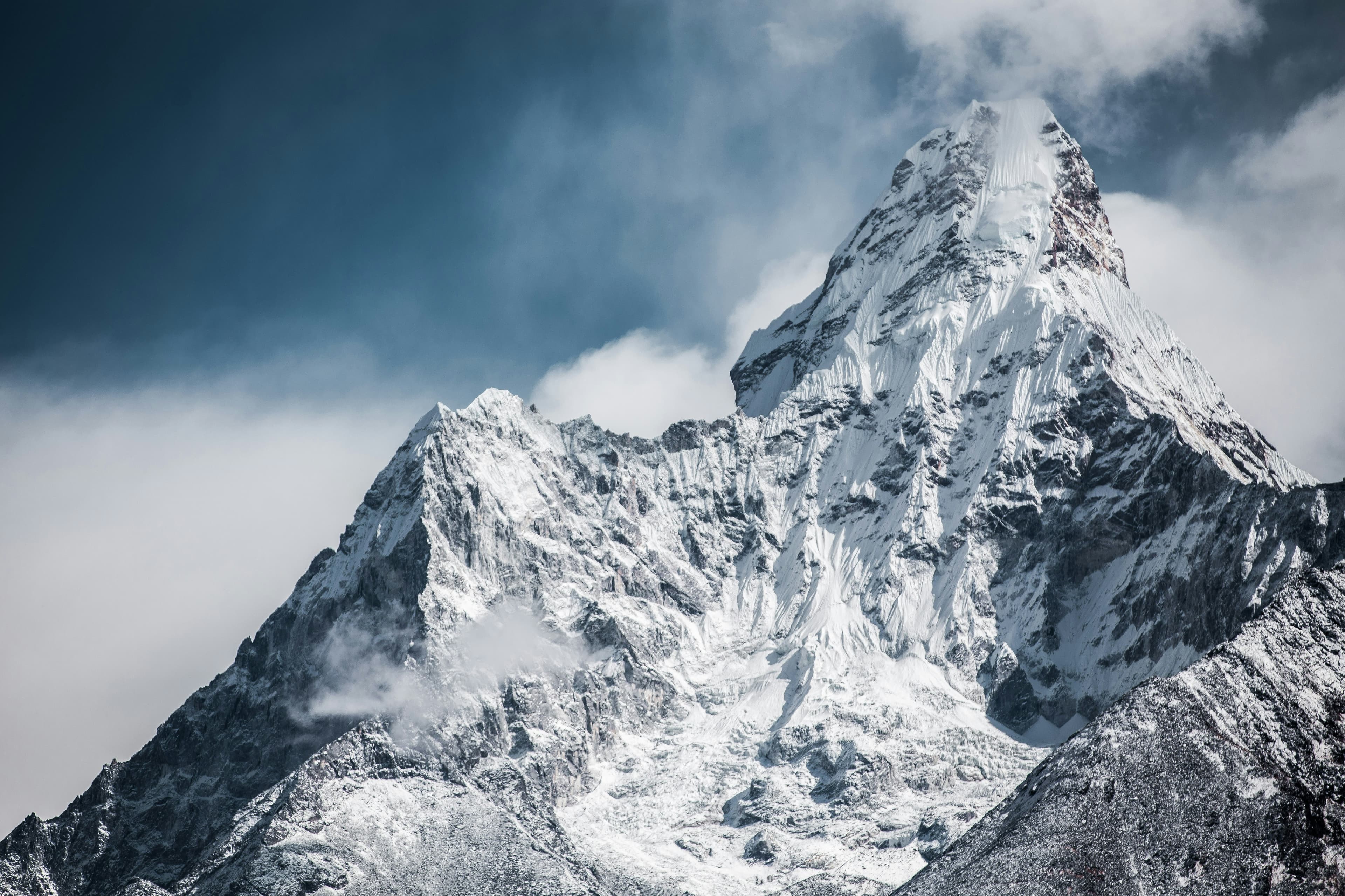 A snow-covered mountain peak under cloud