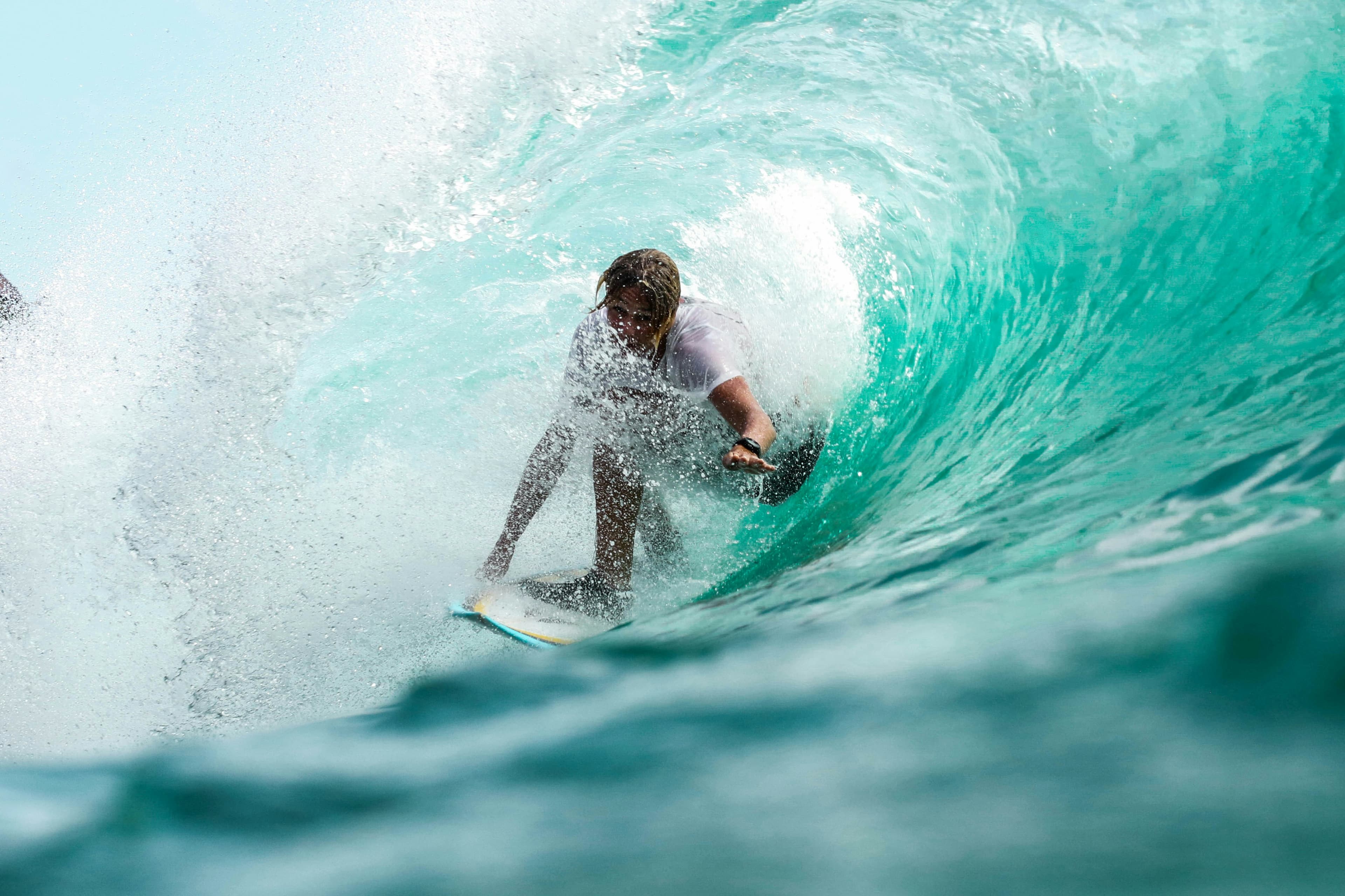 A surfer inside a turquoise wave