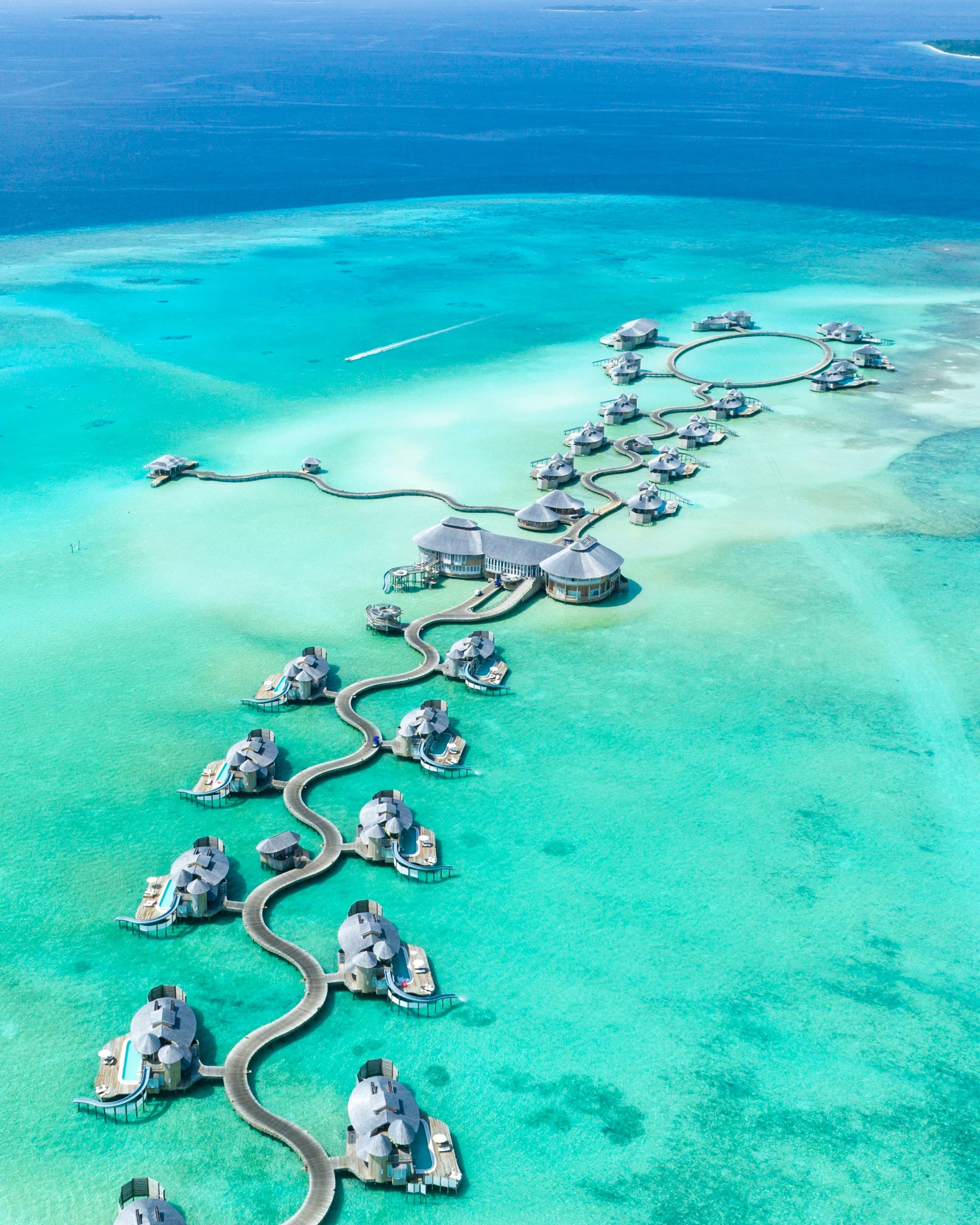 Overwater villas curving across a turquoise lagoon