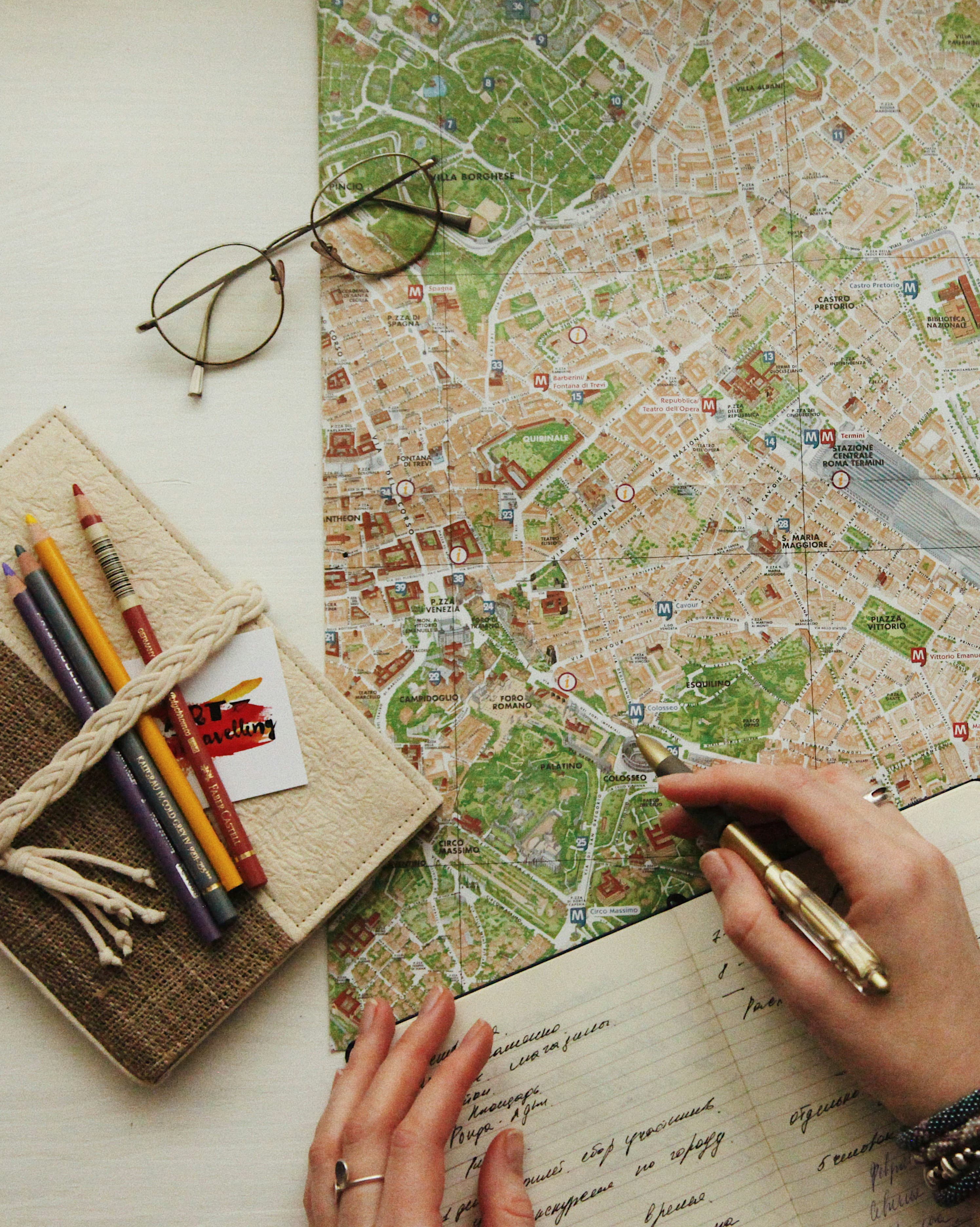 Reading glasses and colored pencils on a printed city map