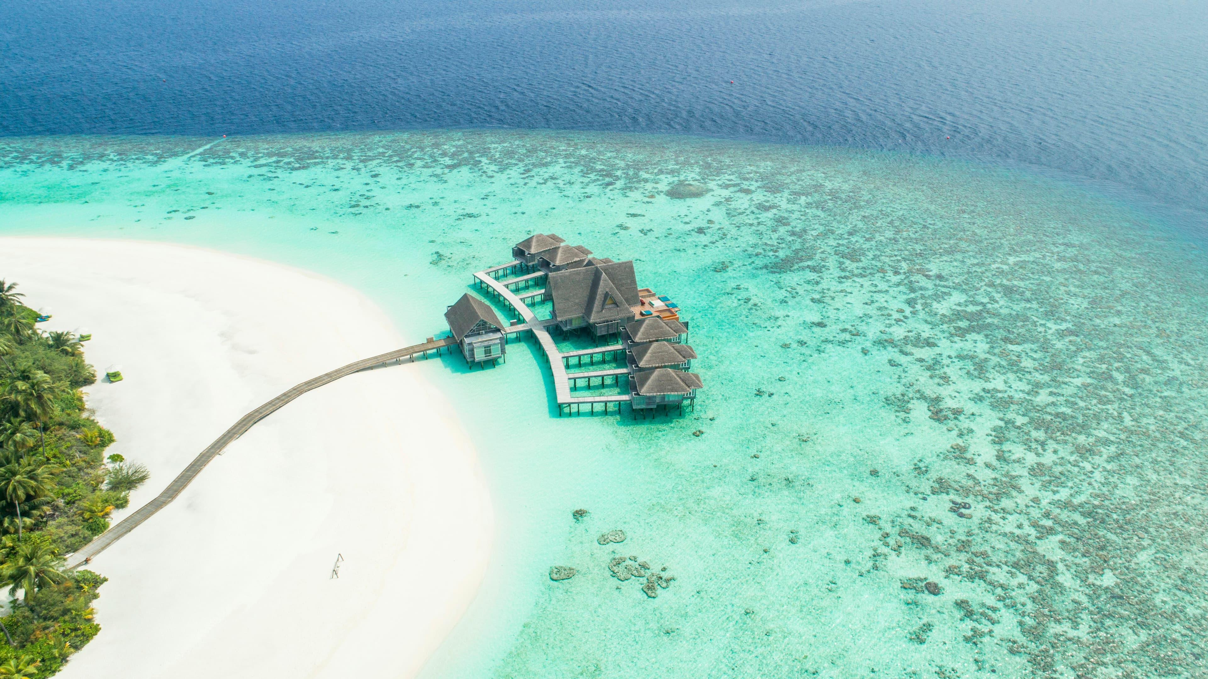 A white sandbank and overwater villas from above