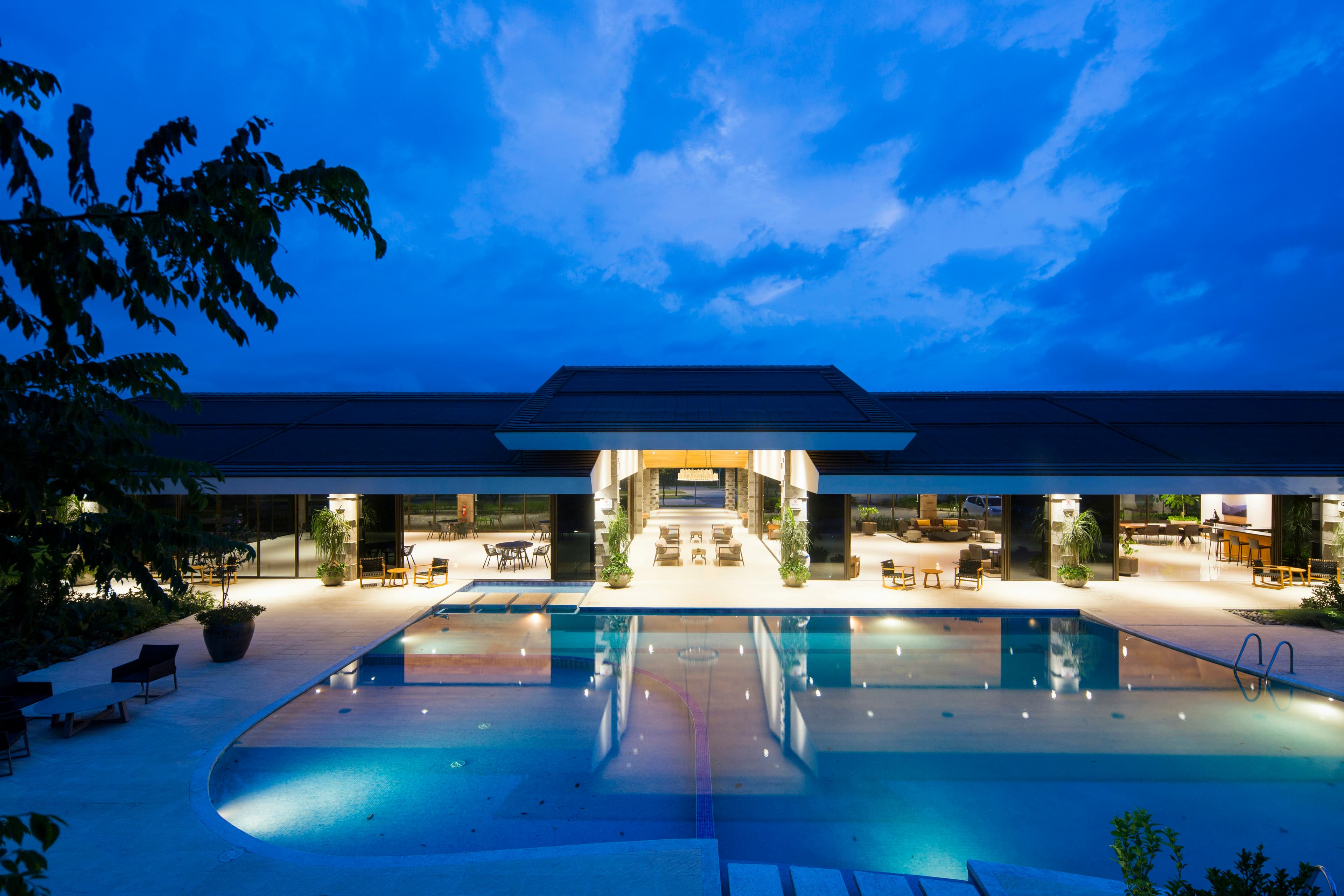 A resort pool lit up at dusk