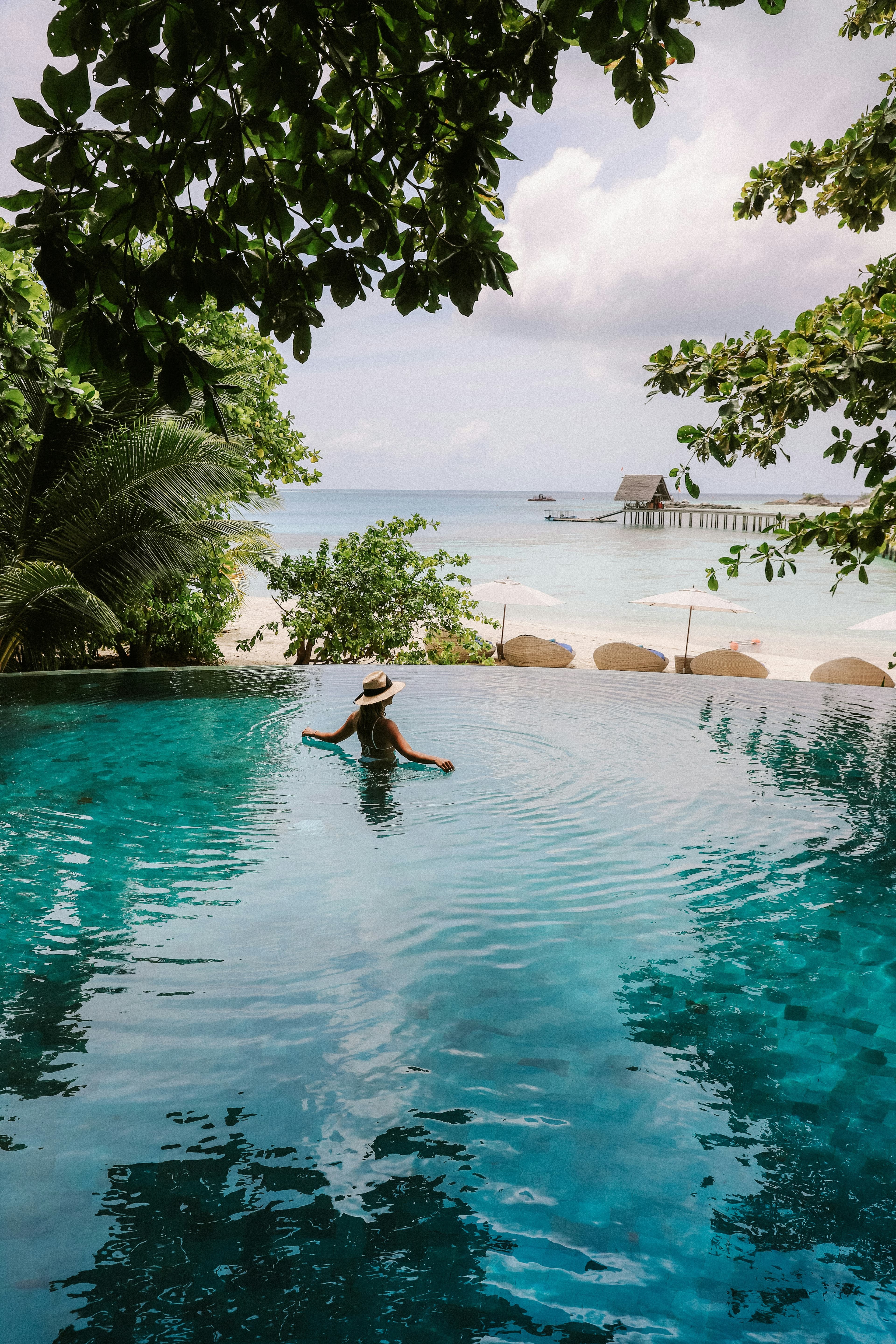 A swimmer in an infinity pool overlooking the sea
