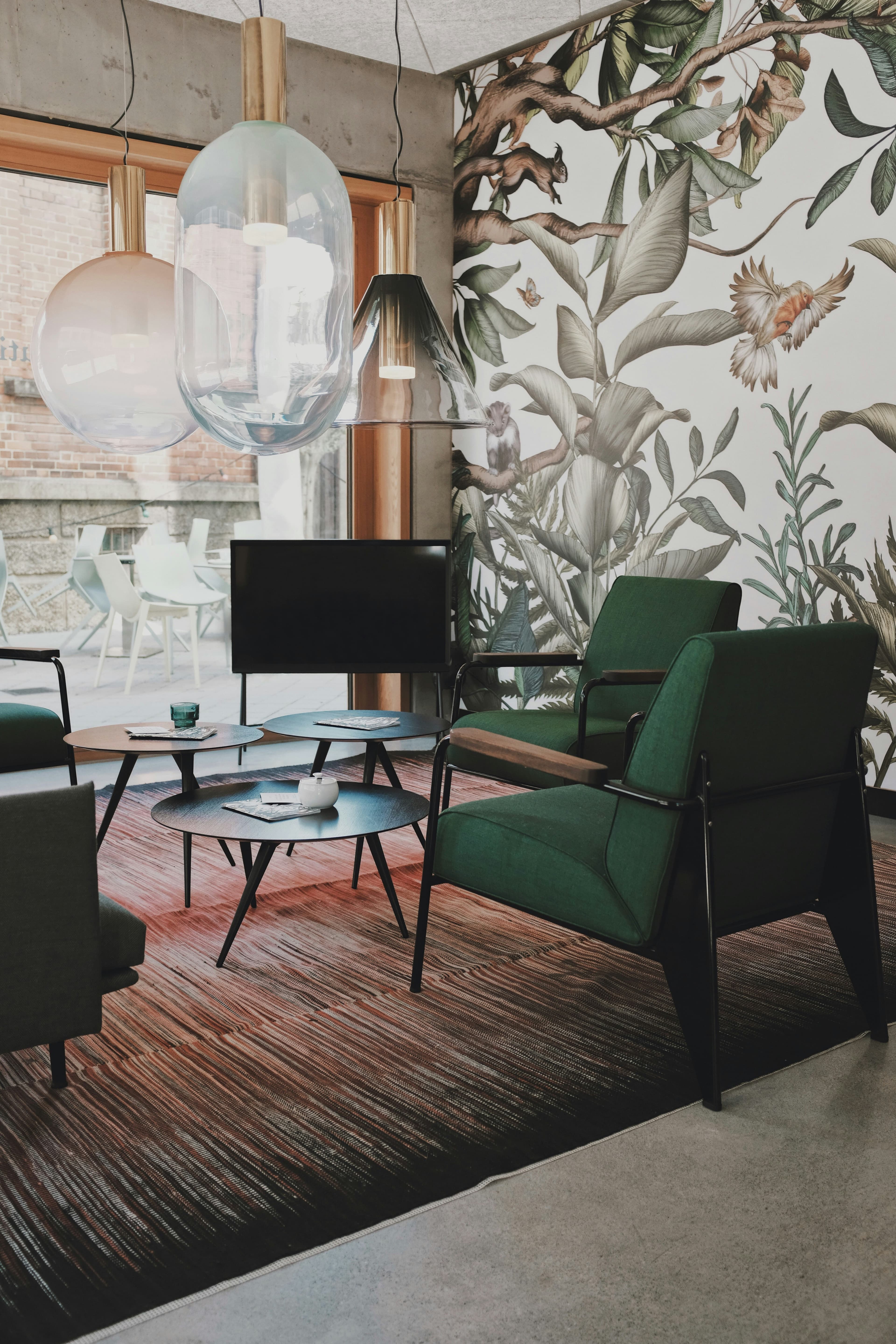 A hotel lounge with green velvet chairs