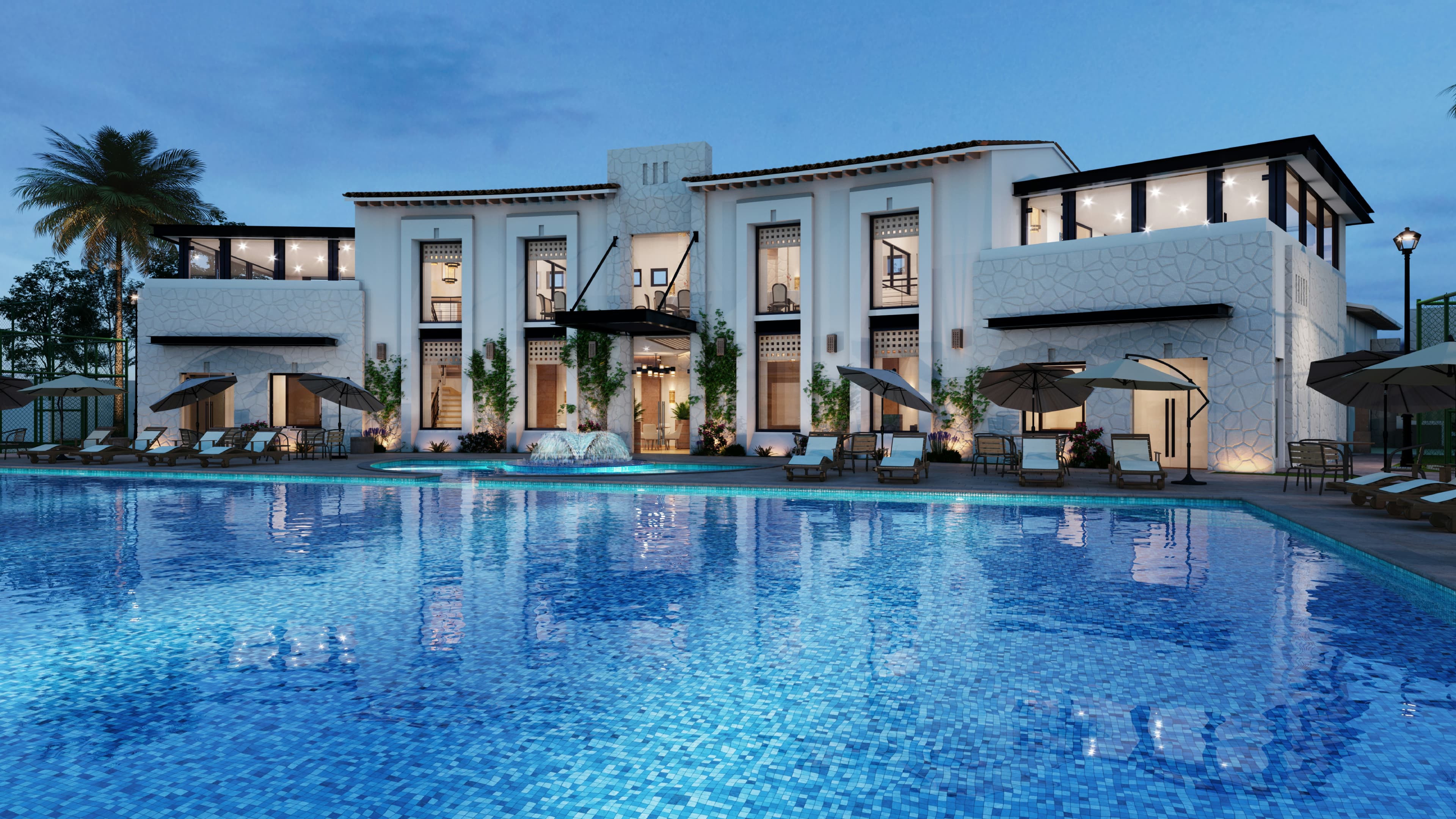 A whitewashed hotel facing a blue pool