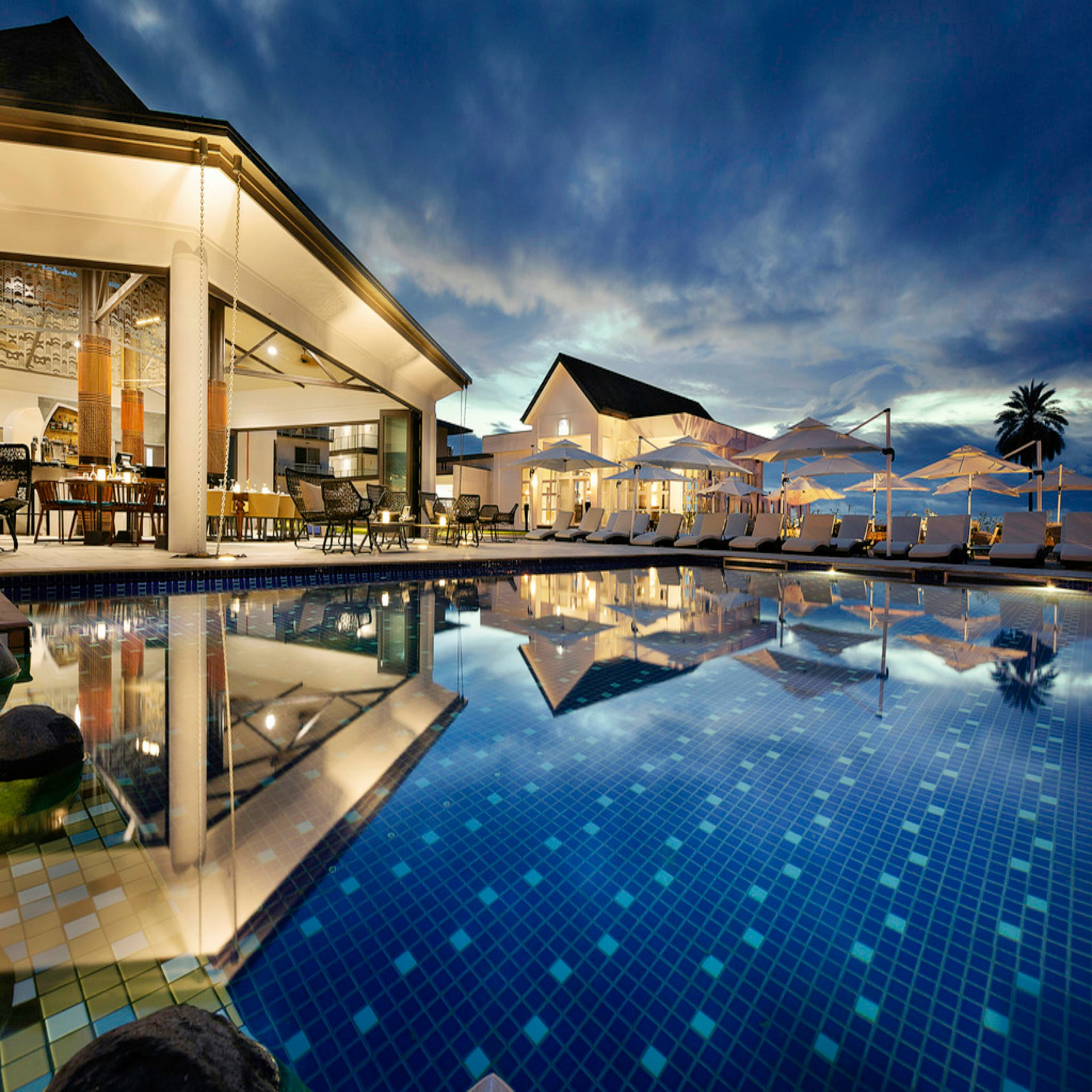 A resort pool reflecting the evening sky