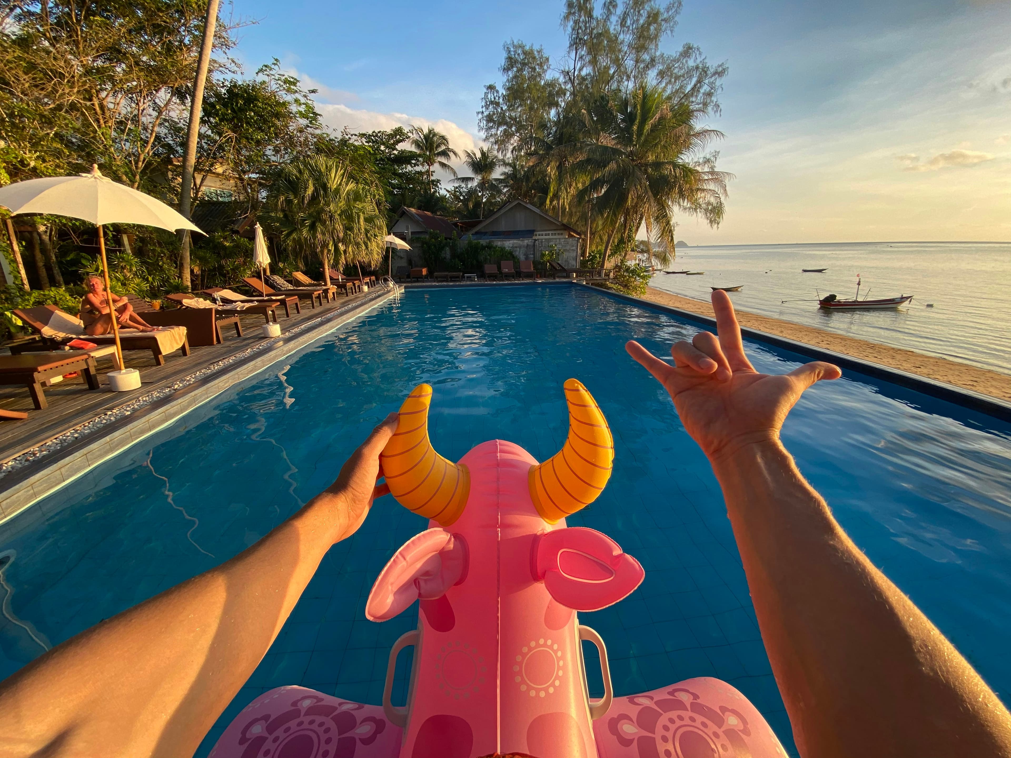 A person lying on a pink float in a swimming pool