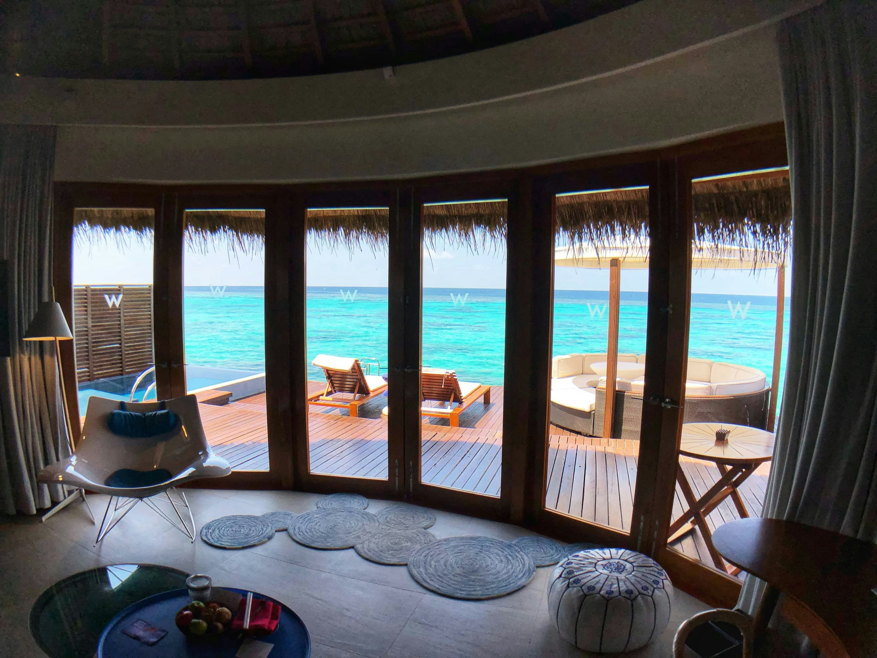 A villa window opening onto a turquoise lagoon