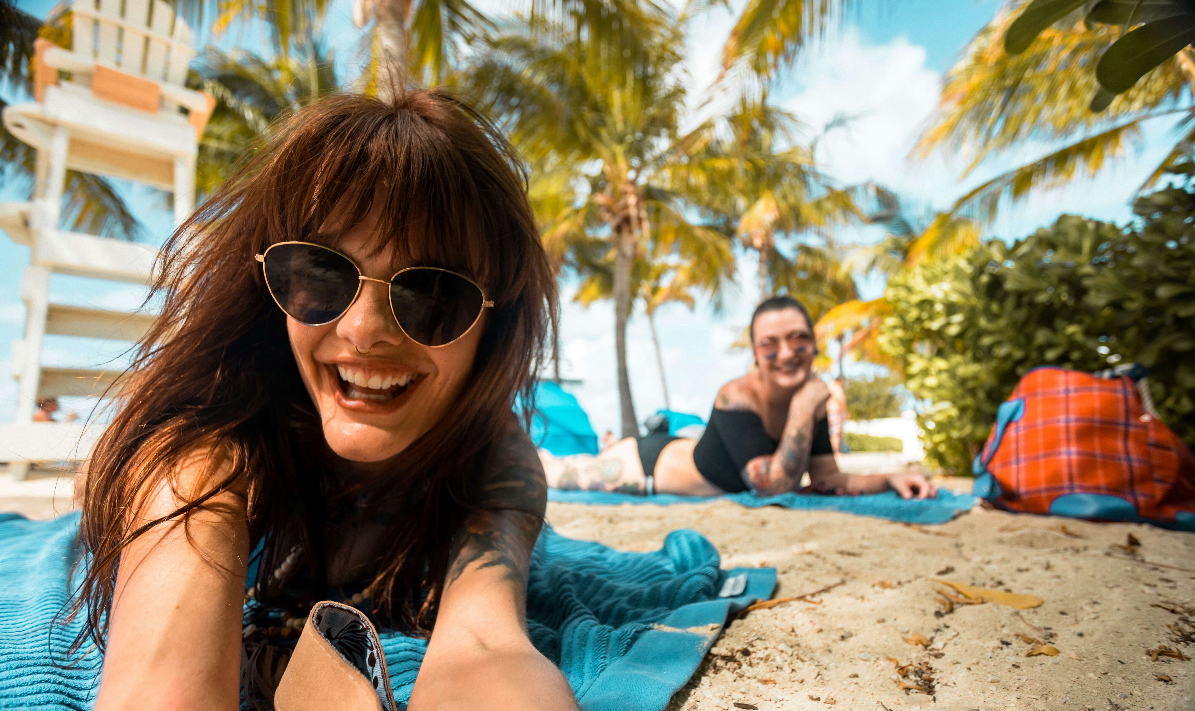A woman lying on a blue towel on a beach